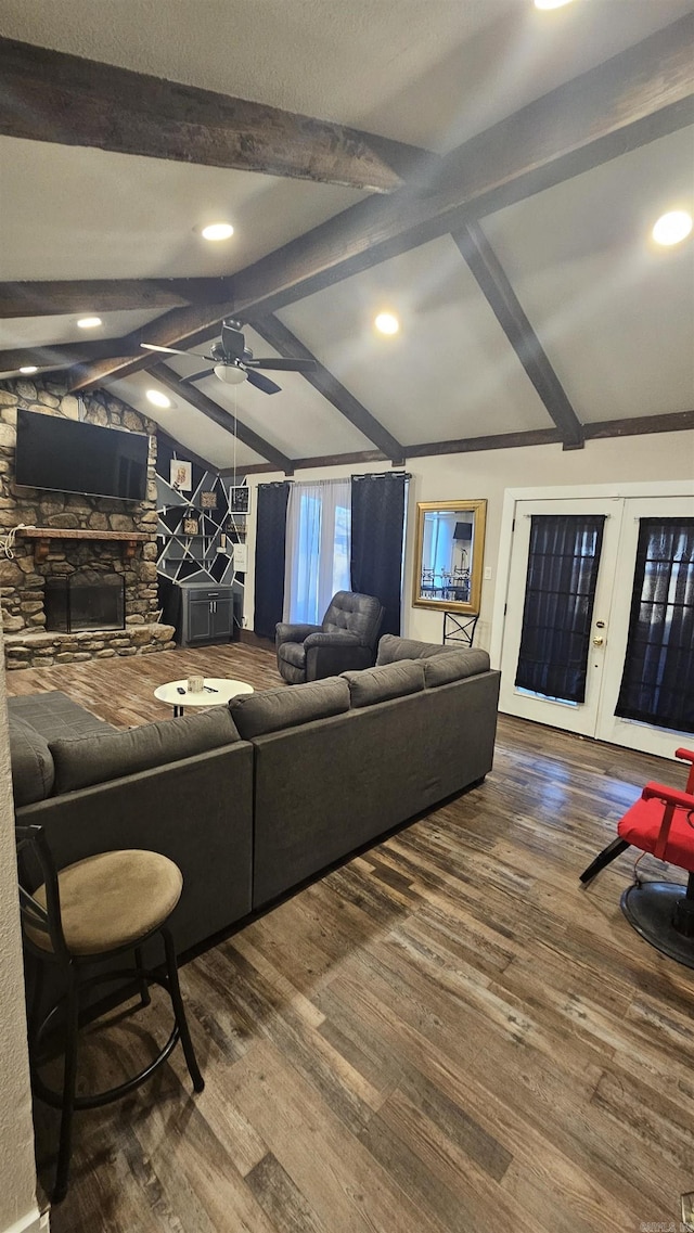 living room with lofted ceiling with beams, ceiling fan, a fireplace, wood finished floors, and french doors