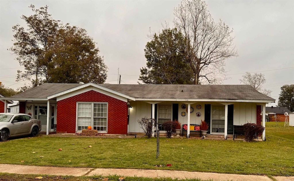 single story home featuring a porch and a front yard