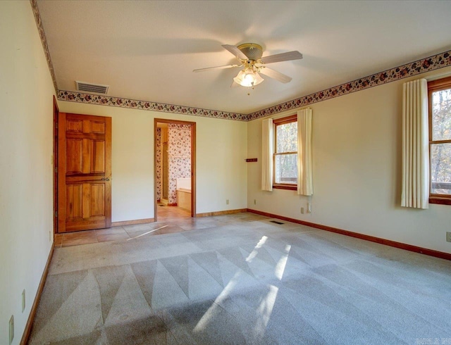 unfurnished bedroom featuring ceiling fan, multiple windows, and light colored carpet