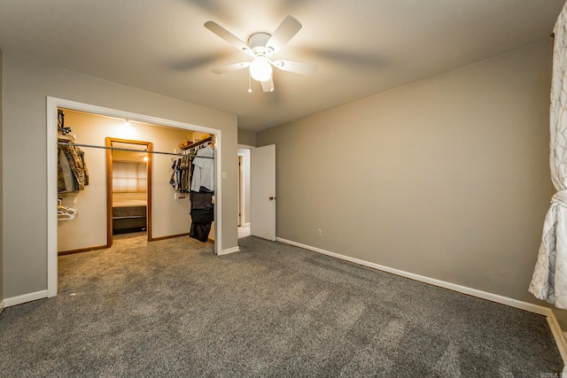 unfurnished bedroom with ceiling fan, carpet flooring, a closet, and a walk in closet