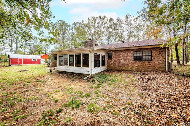 rear view of house featuring a sunroom