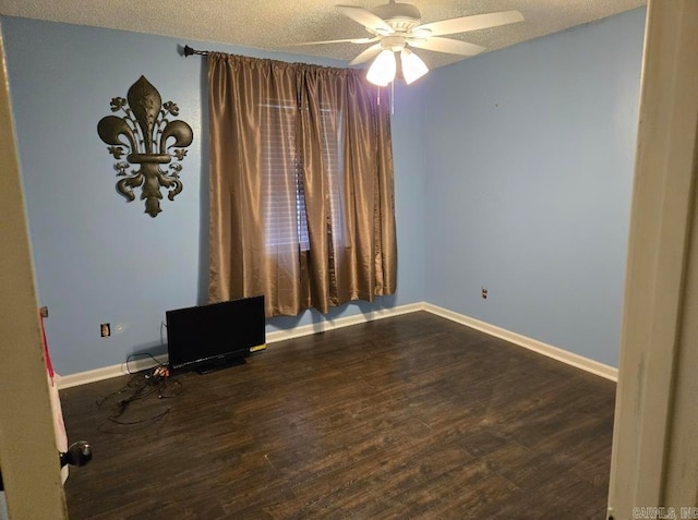 spare room with ceiling fan, a textured ceiling, and dark hardwood / wood-style flooring