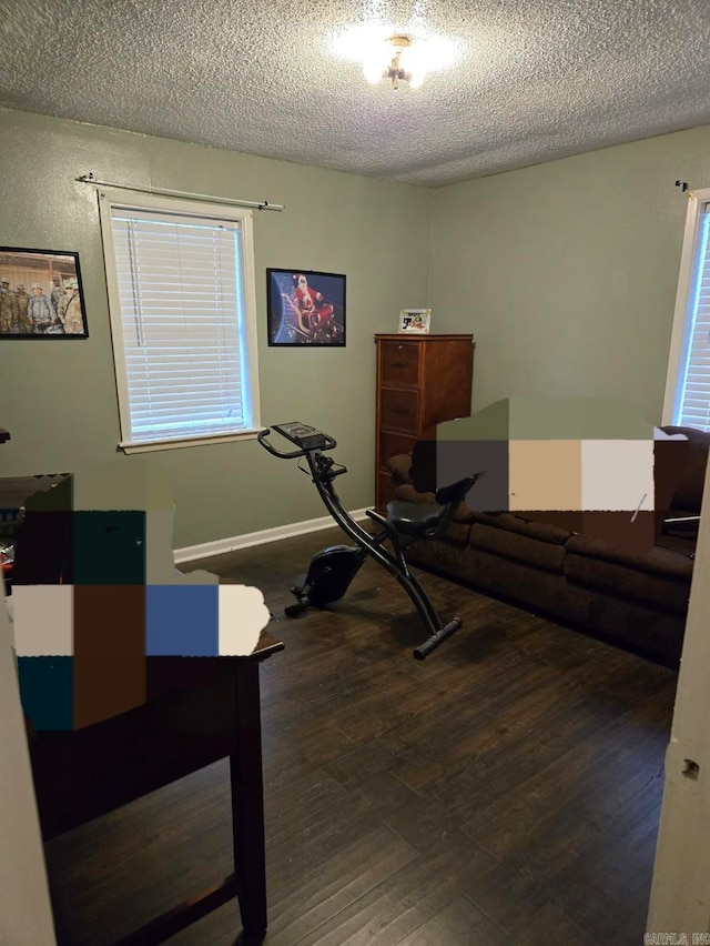 workout area with dark hardwood / wood-style flooring and a textured ceiling