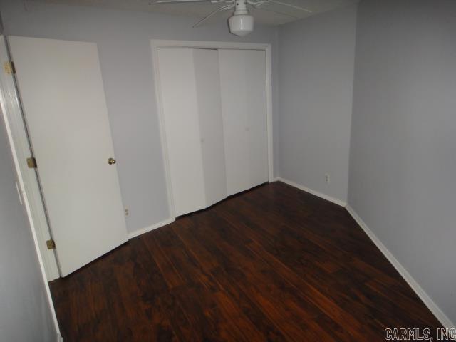 85 Bluff View Dr, Quitman, AR 72131 - unfurnished bedroom featuring wood finished floors, a closet, a ceiling fan, and baseboards