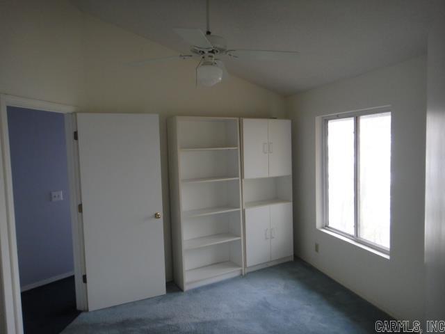85 Bluff View Dr, Quitman, AR 72131 - unfurnished bedroom featuring vaulted ceiling, multiple windows, carpet floors, a ceiling fan, and a closet