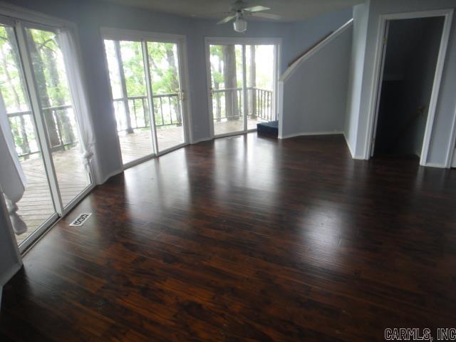 85 Bluff View Dr, Quitman, AR 72131 - empty room featuring healthy amount of natural light, dark wood-style floors, ceiling fan, and baseboards