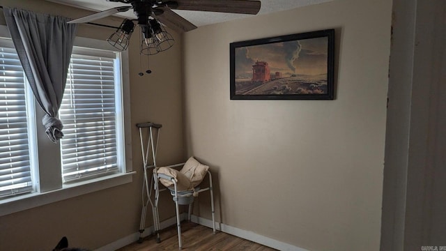 living area featuring hardwood / wood-style floors, ceiling fan, and a textured ceiling