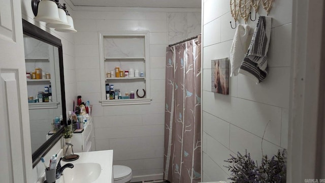 bathroom featuring sink, curtained shower, crown molding, toilet, and tile walls