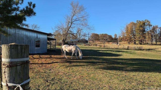 view of yard with a rural view and an outdoor structure