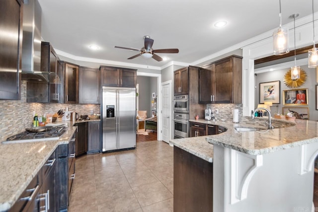 kitchen with stainless steel appliances, sink, light stone counters, a kitchen breakfast bar, and pendant lighting