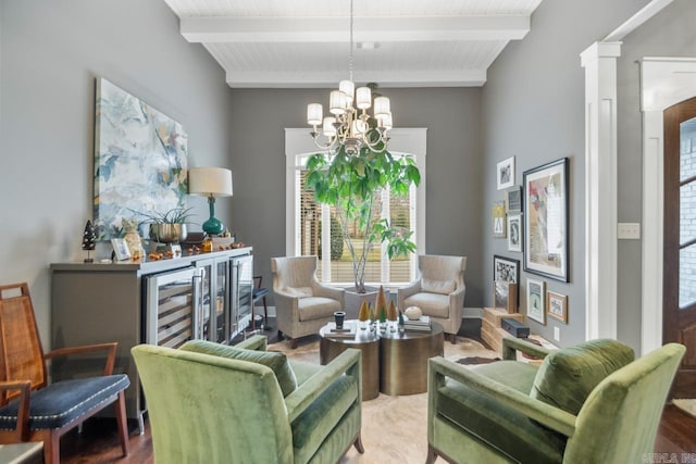 sitting room featuring ornate columns, wood-type flooring, a chandelier, wooden ceiling, and beamed ceiling