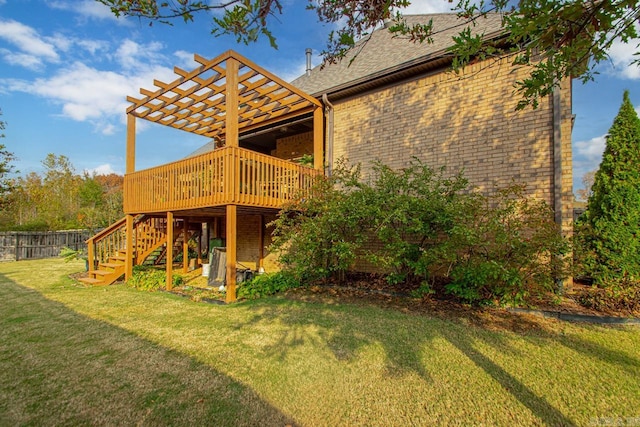 exterior space with a lawn, a wooden deck, and a pergola