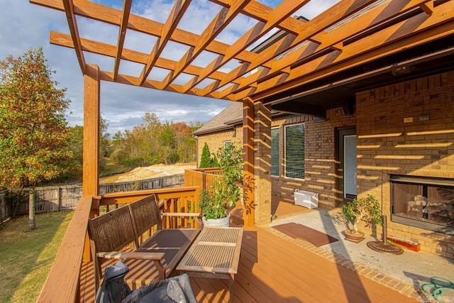 wooden deck featuring a pergola and exterior fireplace