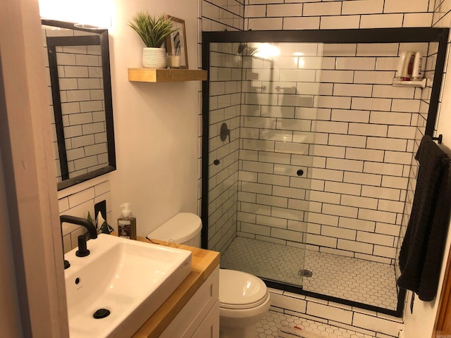 bathroom featuring vanity, tile patterned floors, toilet, and a shower with door