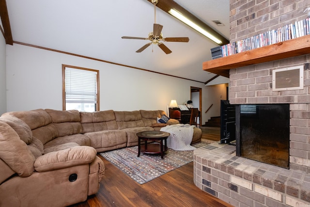 living room with a brick fireplace, dark wood-type flooring, ceiling fan, and crown molding