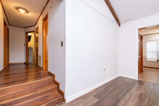 interior space featuring dark hardwood / wood-style floors, a textured ceiling, and vaulted ceiling with beams