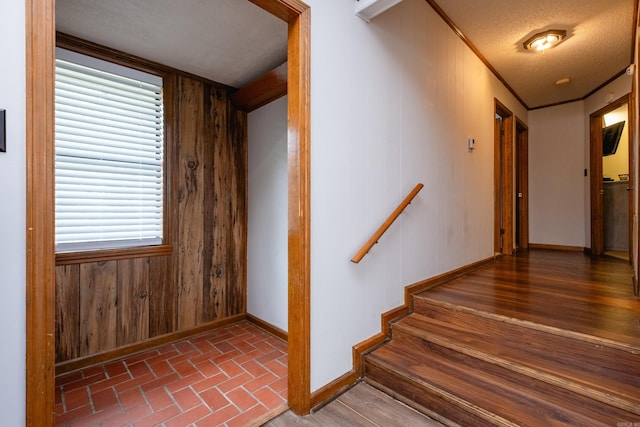 stairs featuring wood walls and a textured ceiling