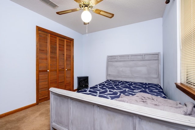 unfurnished bedroom with a closet, a textured ceiling, light carpet, and ceiling fan