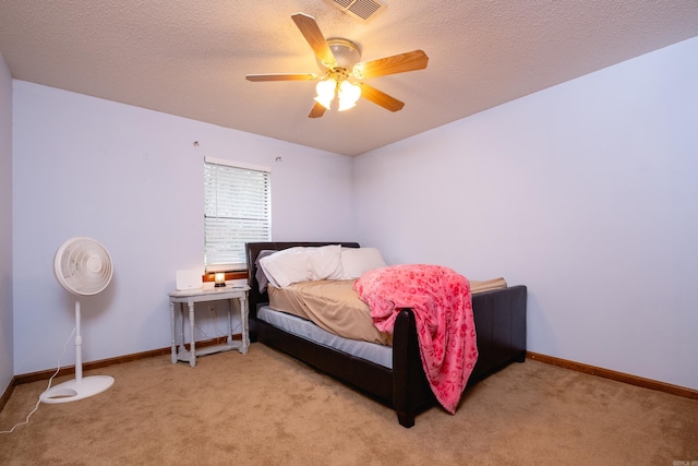 carpeted bedroom featuring a textured ceiling and ceiling fan