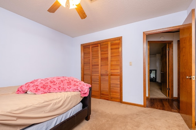 bedroom with a closet, carpet, a textured ceiling, and ceiling fan