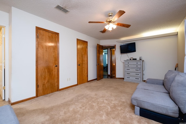 sitting room featuring a textured ceiling, light carpet, and ceiling fan