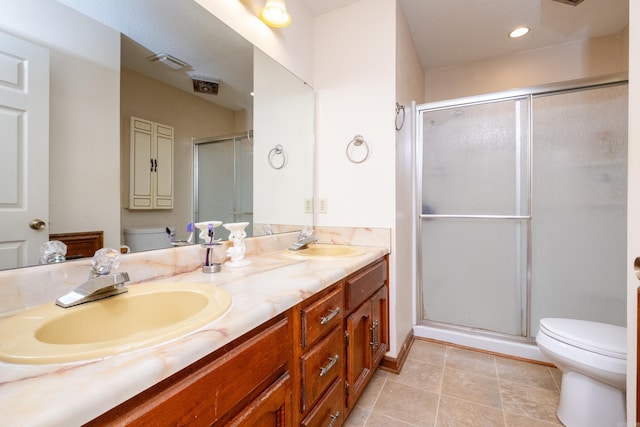 bathroom with toilet, vanity, an enclosed shower, and tile patterned flooring