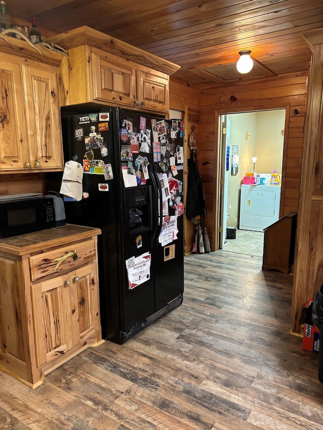 kitchen with black appliances, dark hardwood / wood-style floors, wood walls, washing machine and dryer, and wooden ceiling