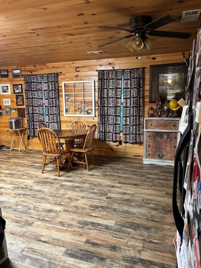 dining space featuring wooden walls, hardwood / wood-style flooring, ceiling fan, and wooden ceiling