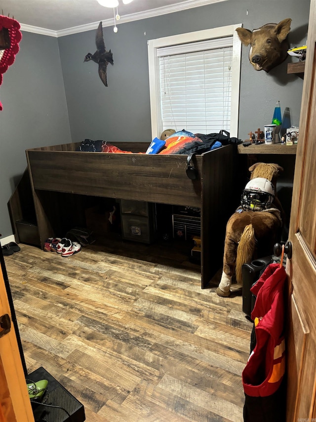 bedroom featuring wood-type flooring and crown molding