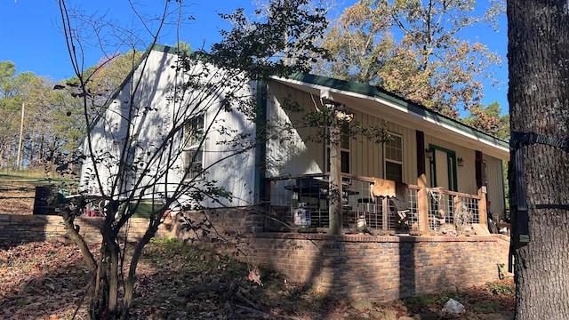 view of side of property featuring covered porch