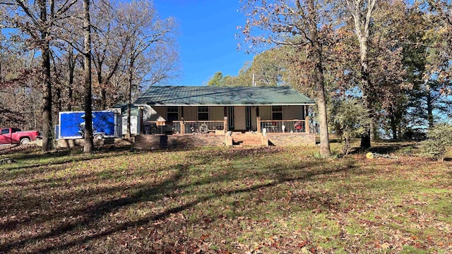 rear view of property featuring a yard and covered porch