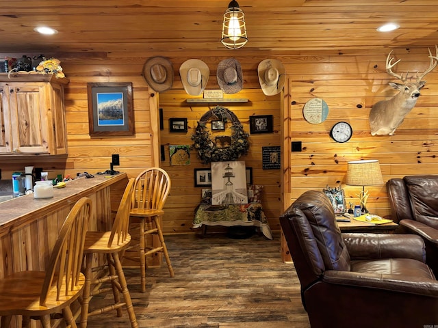 interior space with dark wood-type flooring, wooden walls, and wooden ceiling