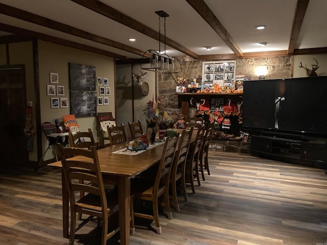 dining space featuring hardwood / wood-style flooring, beamed ceiling, and a notable chandelier