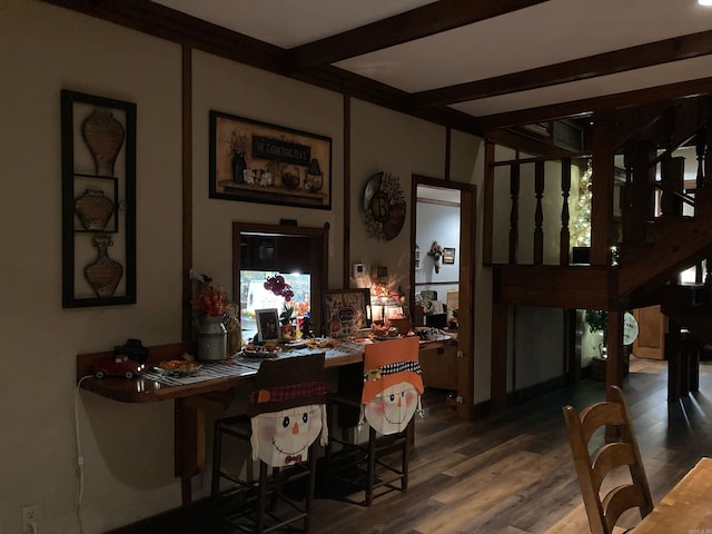 dining space with hardwood / wood-style flooring and beamed ceiling