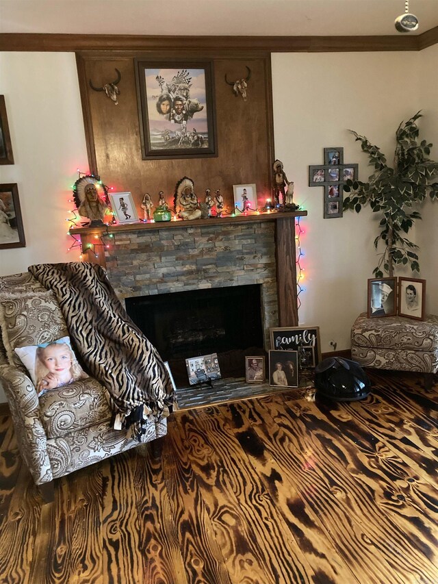 living room with a stone fireplace and crown molding