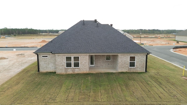 view of property exterior with a patio and a lawn