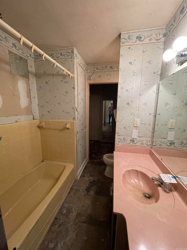 full bathroom featuring toilet, washtub / shower combination, vanity, and a textured ceiling