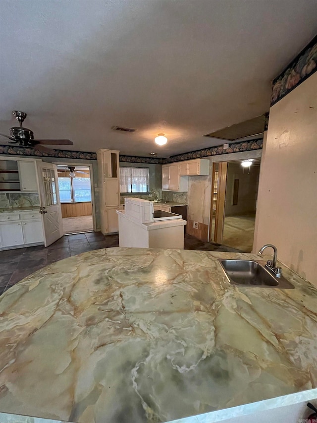 kitchen featuring white cabinetry, kitchen peninsula, sink, and ceiling fan