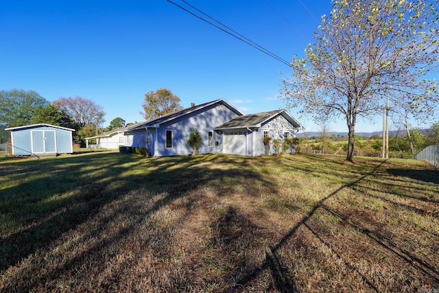 view of side of property with a storage unit and a yard