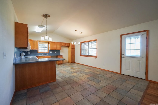 kitchen with a wealth of natural light, hanging light fixtures, sink, and lofted ceiling