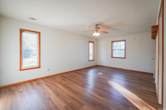 empty room with dark hardwood / wood-style flooring and ceiling fan