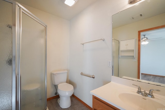 bathroom with a shower with door, tile patterned flooring, ceiling fan, vanity, and toilet