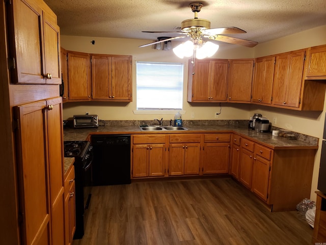 kitchen with a textured ceiling, black appliances, sink, and dark wood-type flooring