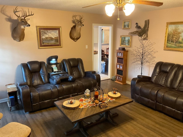 living room with a textured ceiling, ceiling fan, and dark hardwood / wood-style floors