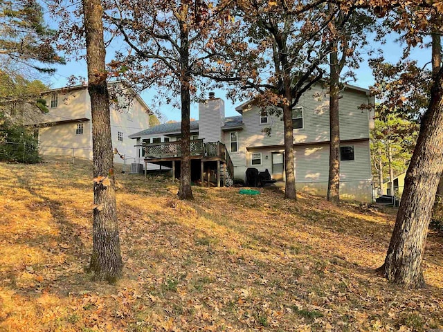 rear view of property featuring a wooden deck and cooling unit