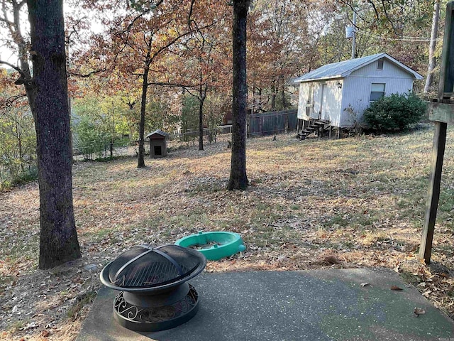 view of yard with a shed and an outdoor fire pit