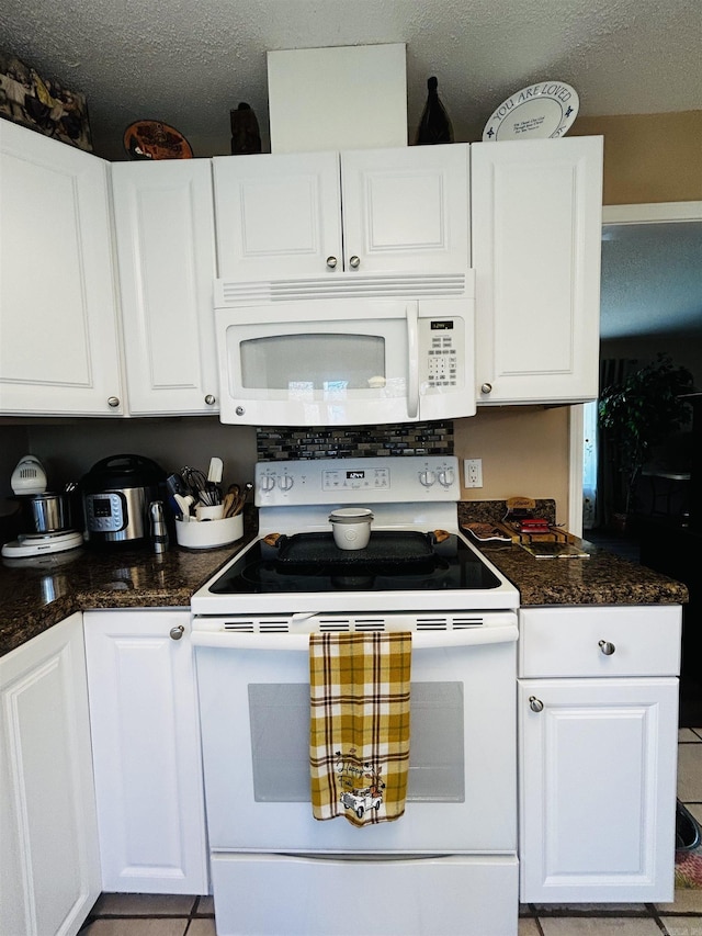 kitchen featuring white cabinetry, white appliances, a textured ceiling, and light tile patterned floors