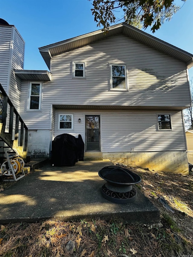 back of property with a fire pit