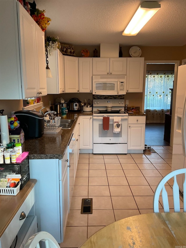 kitchen with white cabinetry, sink, a textured ceiling, white appliances, and light tile patterned floors