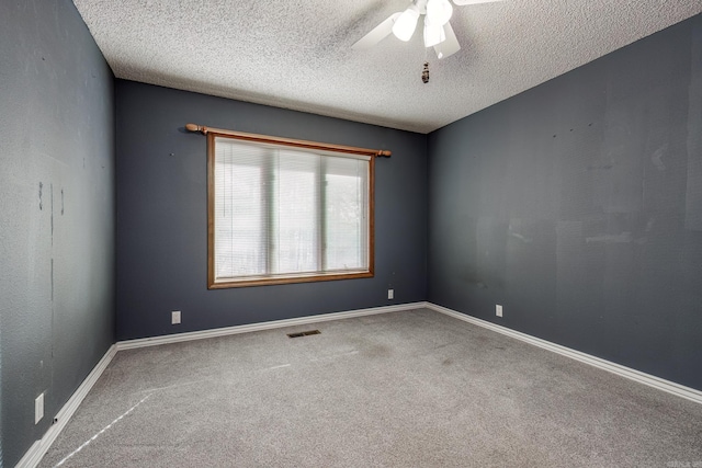 carpeted spare room featuring ceiling fan and a textured ceiling